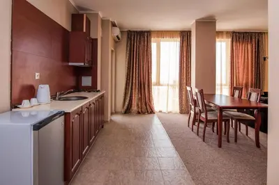 a kitchen and dining room with a table and chairs at Festa Pomorie Resort in Pomorie