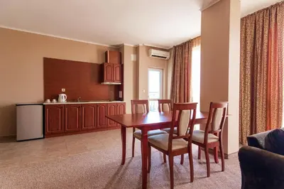 a kitchen and dining room with a table and chairs at Festa Pomorie Resort in Pomorie