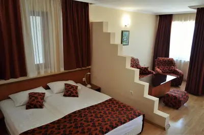 a hotel room with a bed and a staircase at Stankoff Hotel in Nesebar