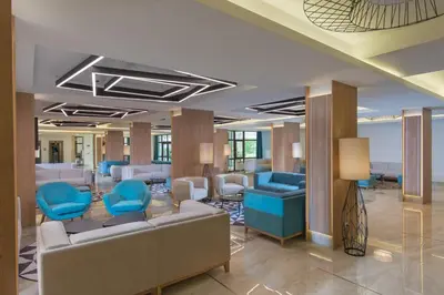 a lobby with blue chairs and a waiting room at Hotel Pomorie Sun - All Inclusive in Sunny Beach