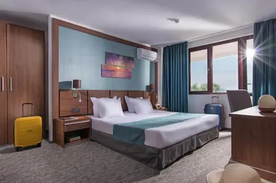 a hotel room with a bed and a desk at Hotel Pomorie Sun - All Inclusive in Sunny Beach