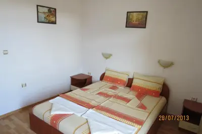 a bed in a room with two pictures on the wall at Hotel Strinava in Primorsko