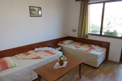 a hotel room with two beds and a table at Hotel Strinava in Primorsko