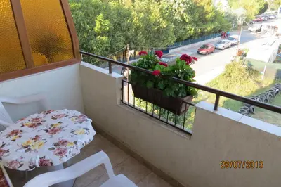 a balcony with a table and flowers on a balcony at Hotel Strinava in Primorsko