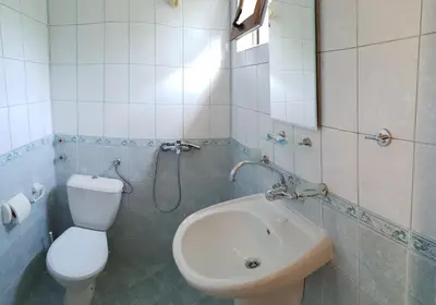 a bathroom with a white toilet and a sink at Hotel Strinava in Primorsko