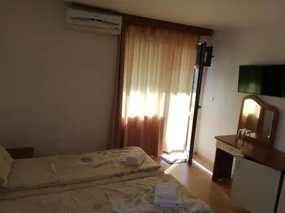a bedroom with a bed and a mirror and a television at Hotel Strinava in Primorsko