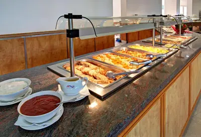 a buffet with many trays of food on a counter at Hotel Fenix - All Inclusive in Sunny Beach
