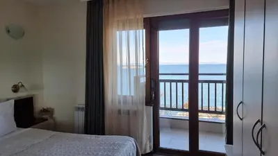 a bedroom with a view of the ocean from a balcony at Hotel Diamanti in Sozopol