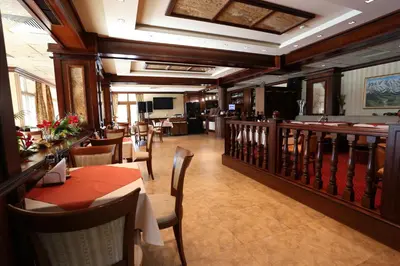 a restaurant with tables and chairs and a bar at Hotel Park in Karnobat