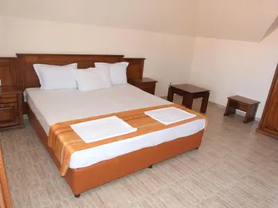 a bedroom with a large bed with two tables at Hotel Beroe in Sveti Vlas