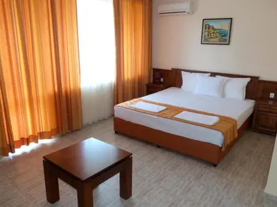a hotel room with a bed and a table at Hotel Beroe in Sveti Vlas