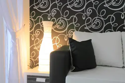 a bedroom with a bed with a lamp on a wall at Hotel Rainbow 3 Resort Club in Sunny Beach