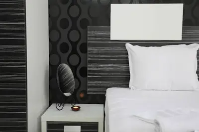 a bedroom with a bed and a night stand with a mirror at Boutique Suites Rainbow 4 in Sunny Beach