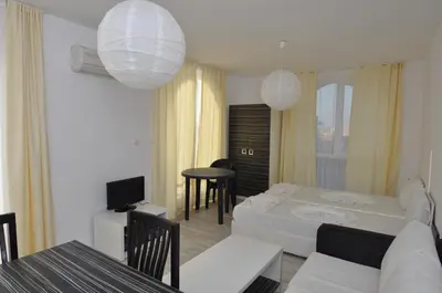 a living room with a bed and a dining room at Boutique Suites Rainbow 4 in Sunny Beach