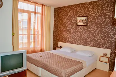 a bedroom with a bed and a television at Rainbow 2 Holiday Complex in Sunny Beach