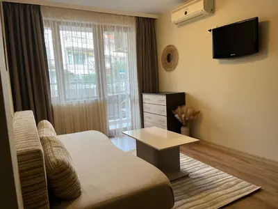 a bedroom with a bed and a tv and a table at Hotel Silver in Sozopol