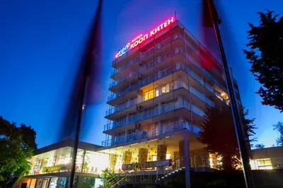 a building with a neon sign on top of it at Hotel Coop - Kiten in Kiten