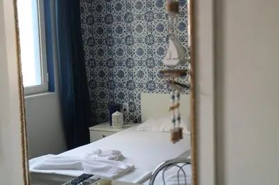a bedroom with a bed and a mirror at Family Hotel Four Seasons Tsarevo in Tsarevo