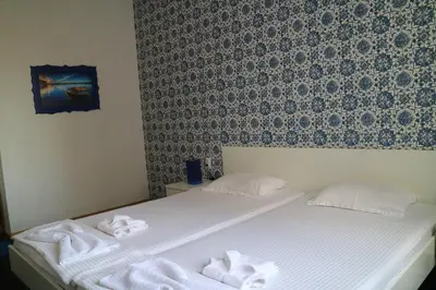 a bedroom with two beds with towels on them at Family Hotel Four Seasons Tsarevo in Tsarevo