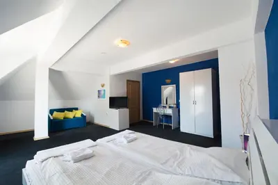 a bedroom with a white bed and a blue wall at Family Hotel Four Seasons Tsarevo in Tsarevo
