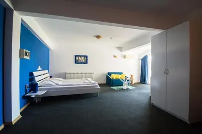 a bedroom with a bed and a blue wall at Family Hotel Four Seasons Tsarevo in Tsarevo