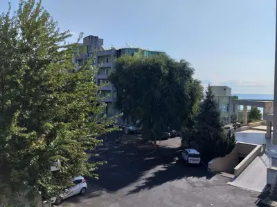 an apartment building with cars parked in a parking lot at Perla Apartments in Nesebar