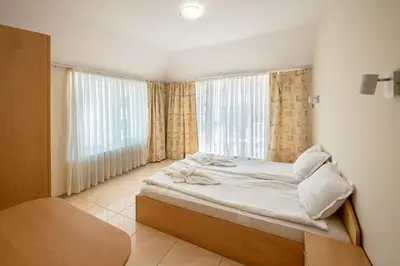 a bedroom with a bed and a large window at Perla Apartments in Nesebar