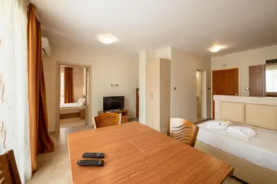 a room with a table and a bed and a bedroom at Perla Apartments in Nesebar