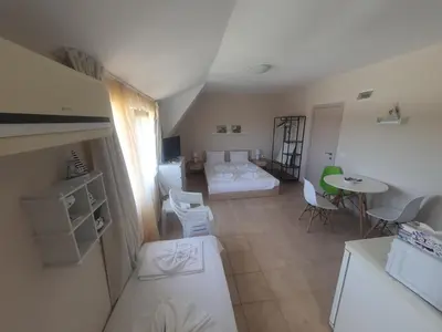 a small room with a bed and a table at Apartments Ivelin in Lozenets