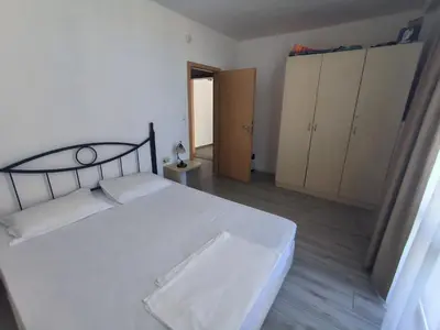 a bedroom with a large white bed and cabinets at Complex Sands Holiday Apartments in Sunny Beach