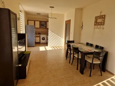 a kitchen and dining room with a table and chairs at Apartment Kalin complex Aurelia-RAVDA in Nesebar