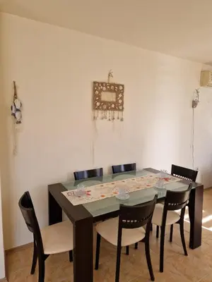 a dining room with a black table and chairs at Apartment Kalin complex Aurelia-RAVDA in Nesebar