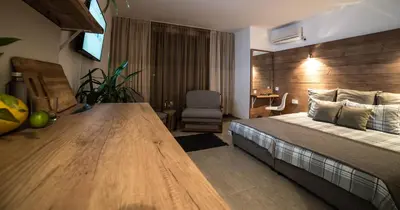 a bedroom with a large bed and a wooden wall at The Poolhouse in Sunny Beach