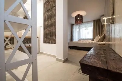 a living room with a bed and a wooden table at The Poolhouse in Sunny Beach
