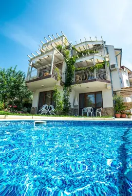 a house with a swimming pool in front of it at The Poolhouse in Sunny Beach