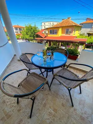 a table and chairs on a patio with a table and drinks at Apartments Yana in Obzor