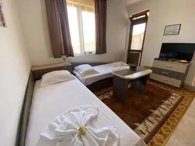 a hotel room with two beds and a television at Apartments Yana in Obzor