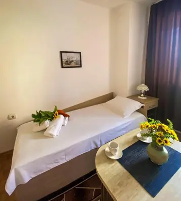 a hotel room with a bed and a table at Apartments Yana in Obzor