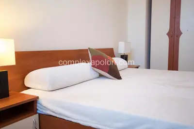 a bedroom with a bed with a white pillow and a lamp at Complex Apolon in Nesebar