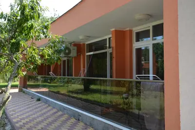 a house with a balcony with a glass fence at Hotel Neva in Kiten