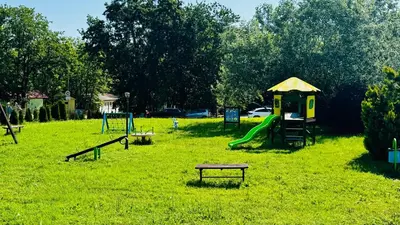 a park with a playground with a slide and a table at Hotel Neva in Kiten