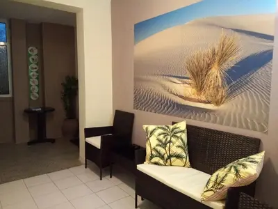 a living room with a couch and a painting on the wall at Guesthouse Oasis in Kiten