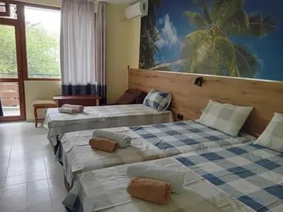 a hotel room with three beds in a room at Guesthouse Oasis in Kiten