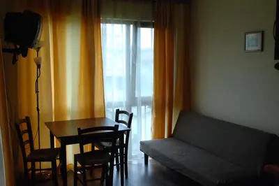 a living room with a couch and a table with chairs at Condo Hotel Valentina in Obzor