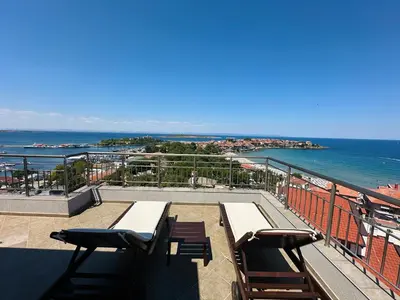 a balcony with a table and chairs and the ocean at Family Hotel Radiana in Sozopol