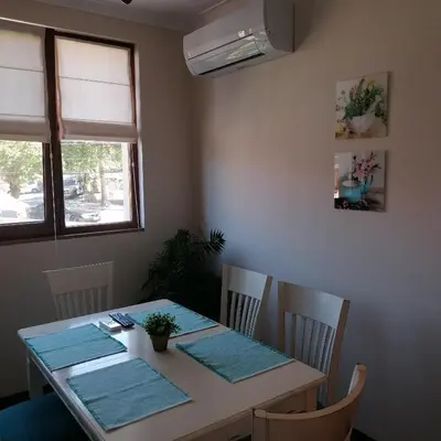 a dining room with a table with blue mats on it at Apartments Dona in Chernomorets