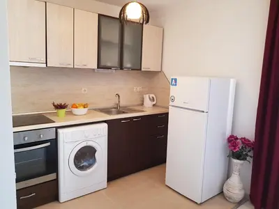 a kitchen with a washing machine and a refrigerator at Family Aparthotel Vintegra in Burgas City