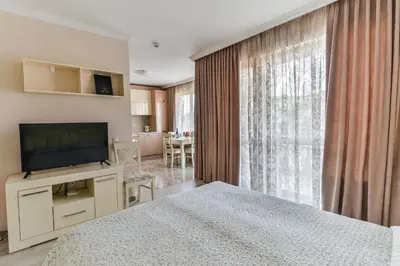 a bedroom with a bed and a flat screen tv at VILLA FLORENCE Boutique Apart Hotel in Sveti Vlas
