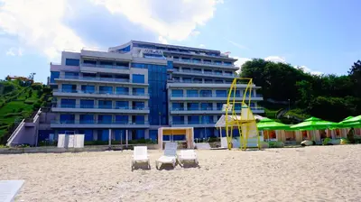 a building on the beach with two chairs and a life guard at Aurora apartments on the beach in Obzor