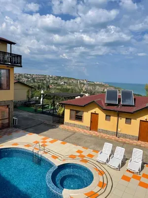 a swimming pool with two chairs and a house at Complex Terazini in Byala
